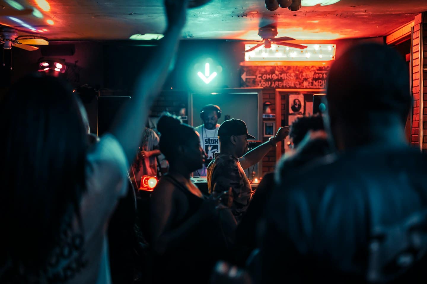 Gente bailando alegremente bajo luces de neón en una fiesta.