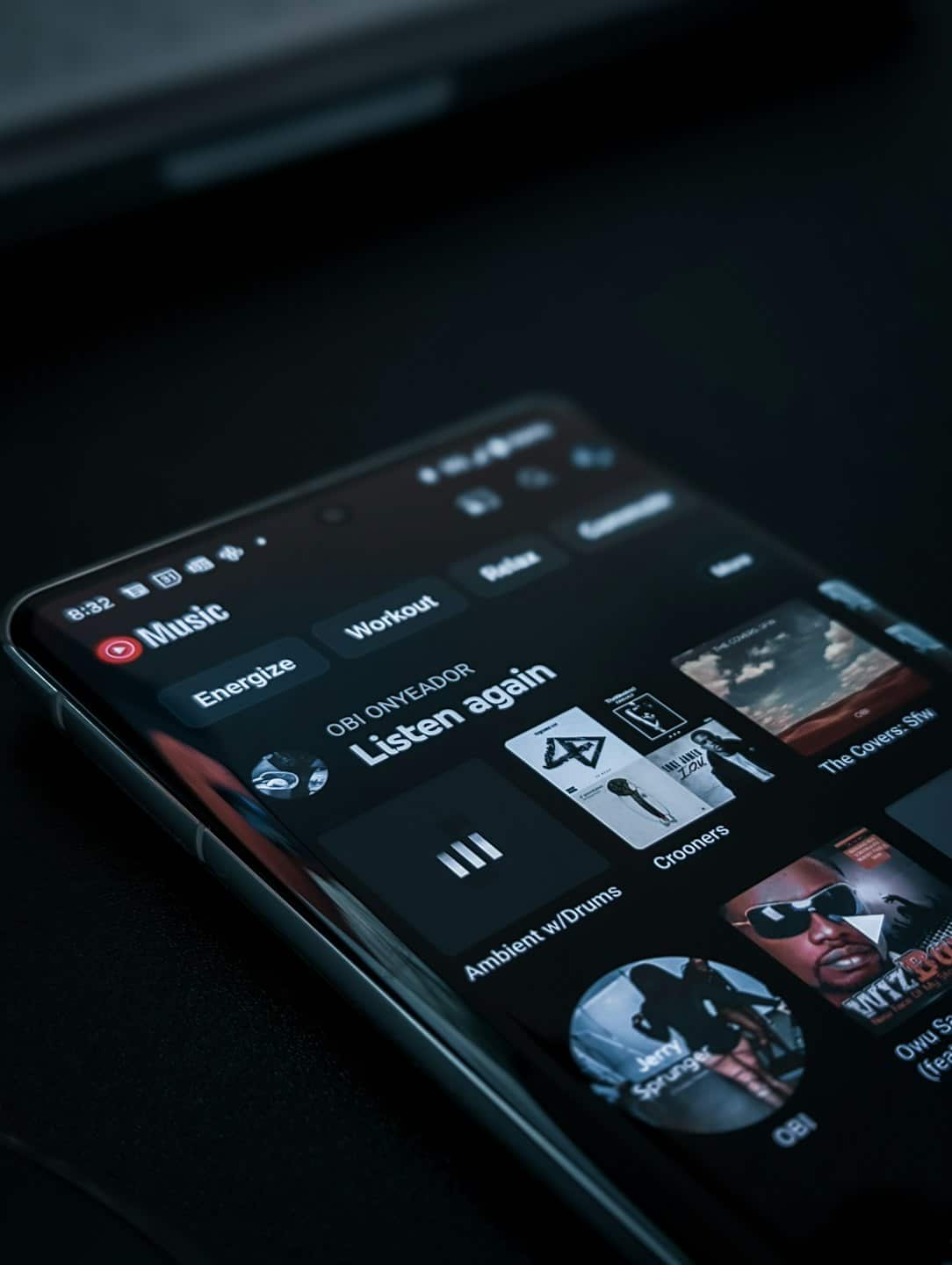 Pantalla de smartphone mostrando una aplicación de streaming de música con carátulas de álbumes.