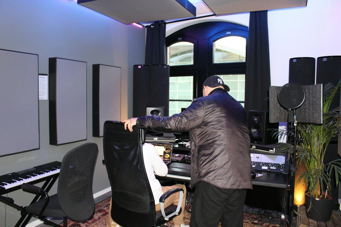 Dos hombres trabajando juntos en un estudio de grabación bien iluminado.